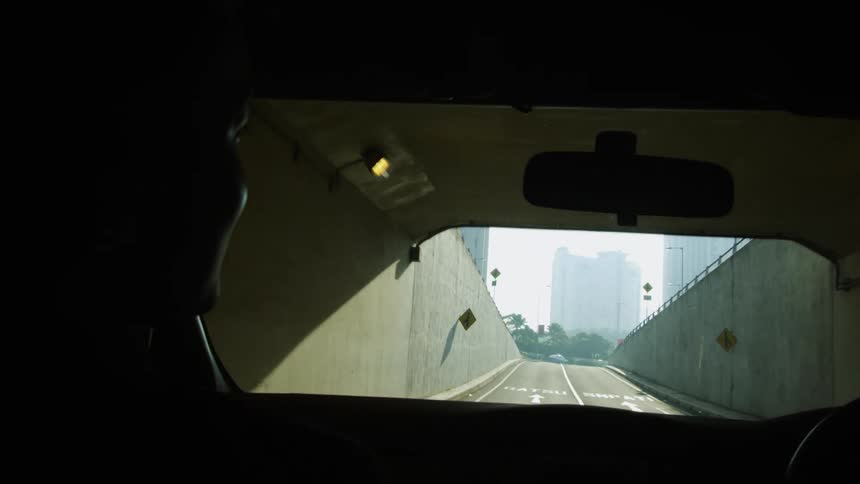 Car driving out of a tunnel on the city at daytime