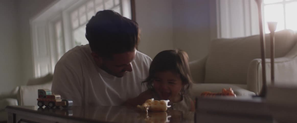Father plays with his child in the living room at home