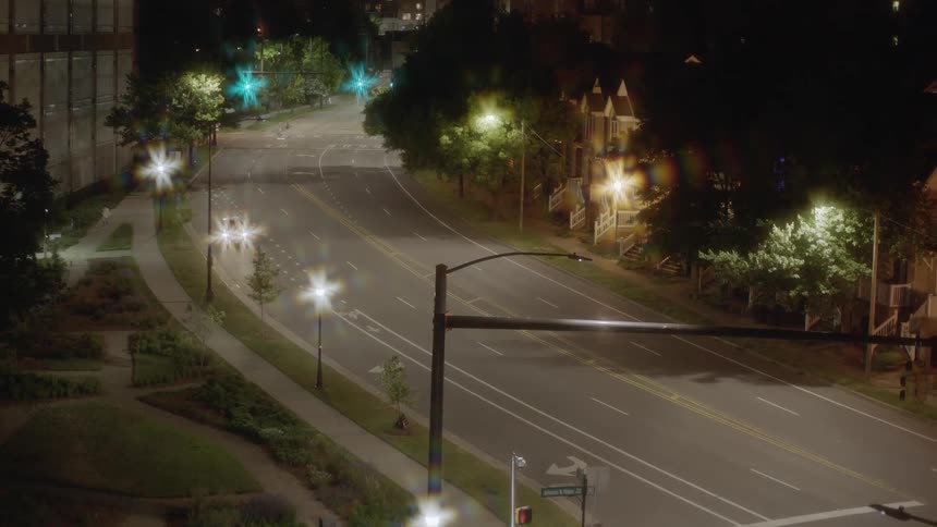 A car is driving through a downtown city at night