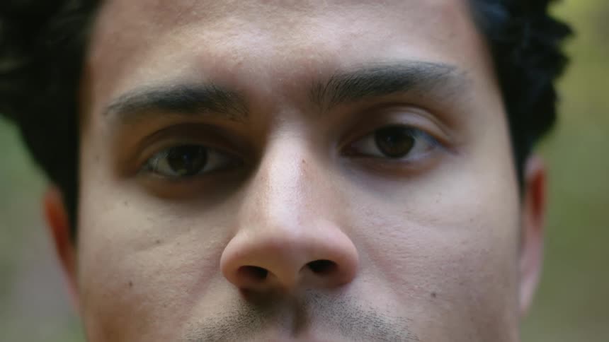Man with curly hair faces the camera with eye contact