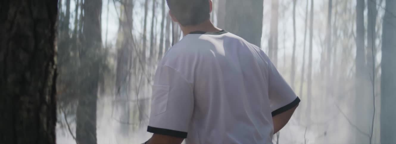 Man walks carefully through woods looking through fog