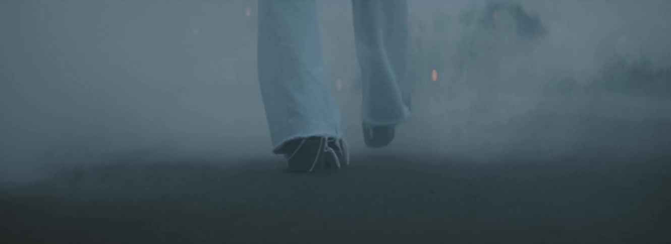 Person walking on a smoke covered street at evening