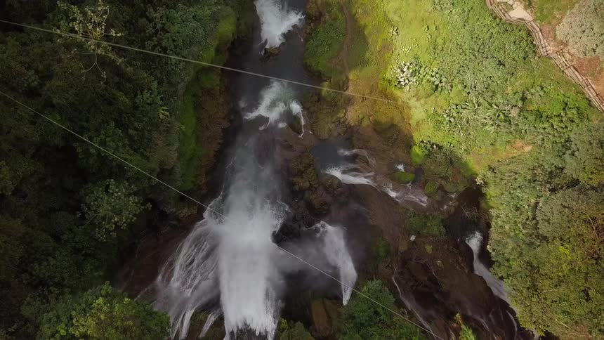 The waterfall pours into the stream