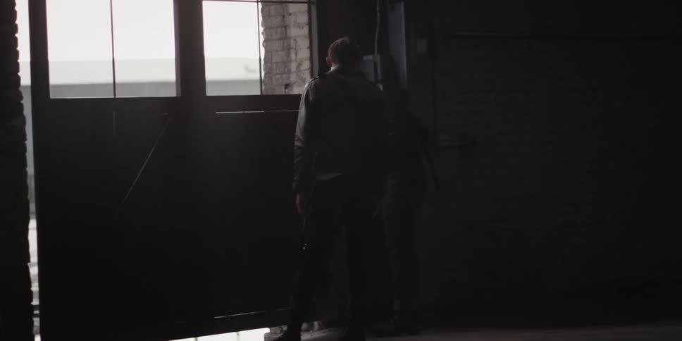A man is standing in an empty room near a window