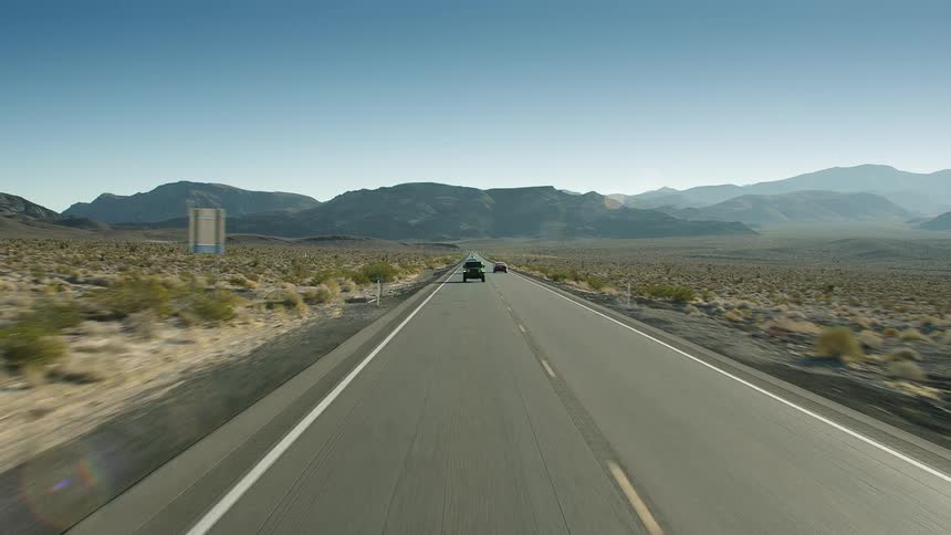 Traffic on a road with mountains in the distance
