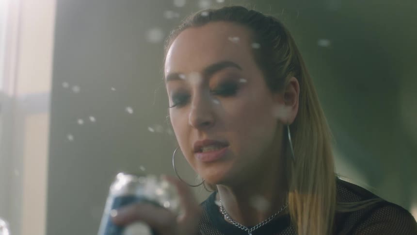 A woman grimaces as she shakes and empties two beer bottles