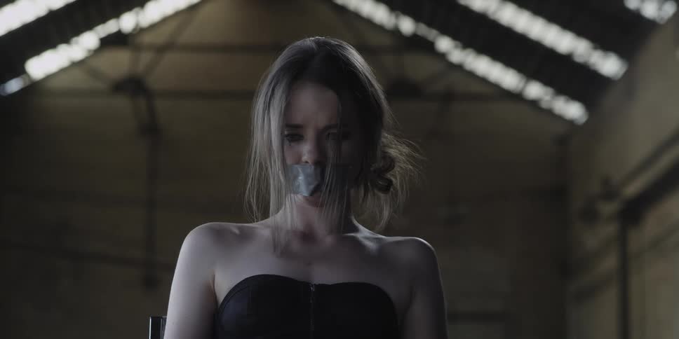 A woman looks sad while standing in an empty building