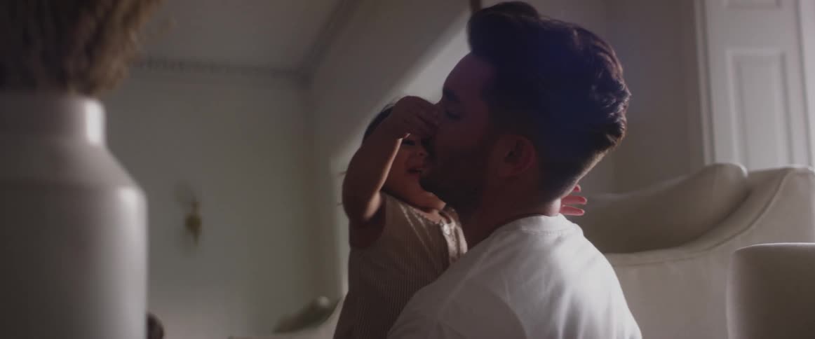 Father plays with excited child in living room