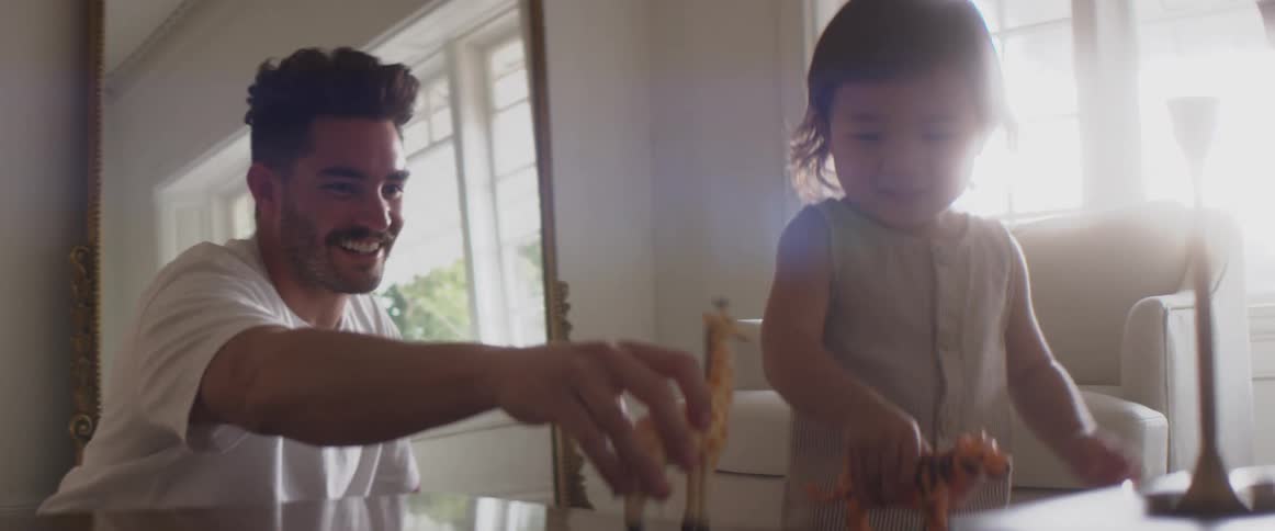 A father and child play with toy animals