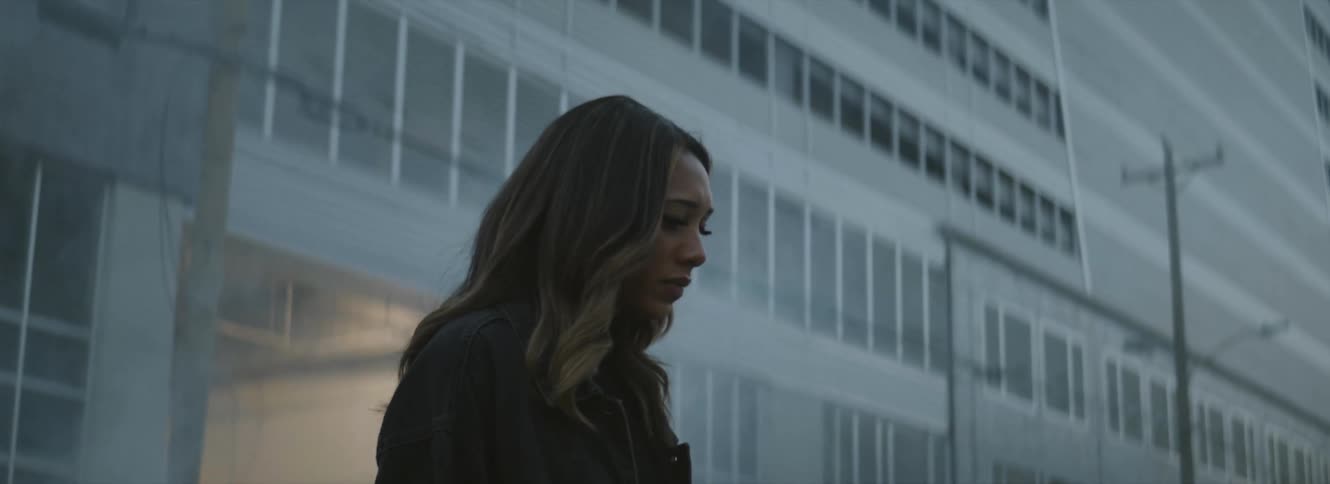 Young woman walking through the smoke on the city at evening