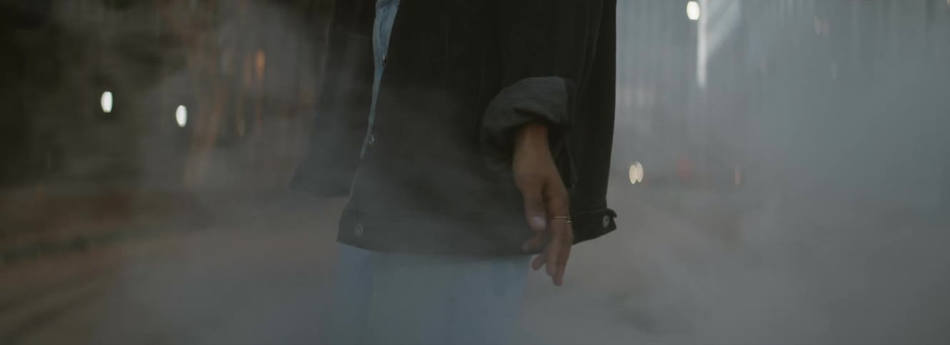 A woman walks across a fog covered bridge