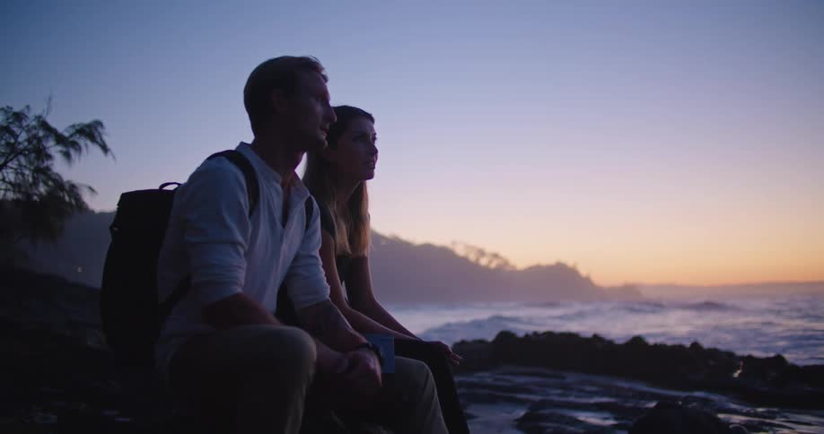 Man and woman relaxing by a body of water