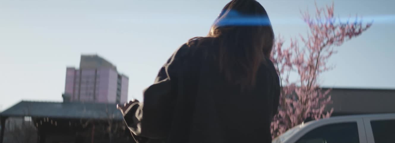 A woman is walking outdoors in a downtown city during spring