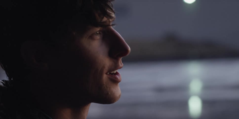 Close up of the face of a young man talking outdoors