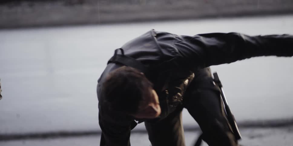 A man with a holster and a hatchet climbs up onto a platform to investigate something
