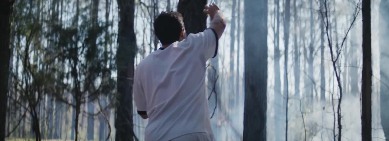 A man is walking through a forest and looks lost