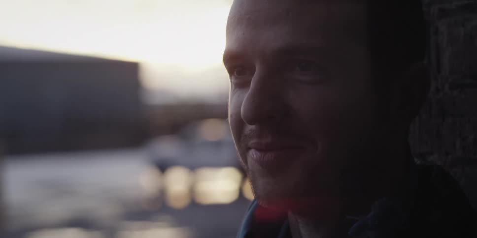 Close up of a man smiling in the city at sunset