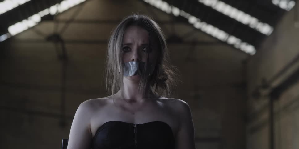 A woman is in a chair with tape on her mouth