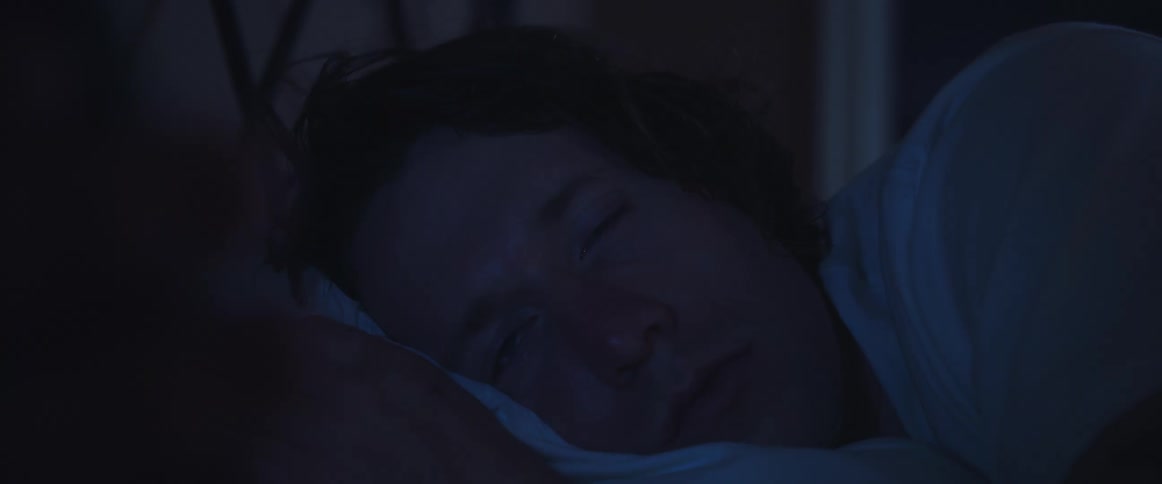 Long haired man falling asleep in the bed on the bedroom at home