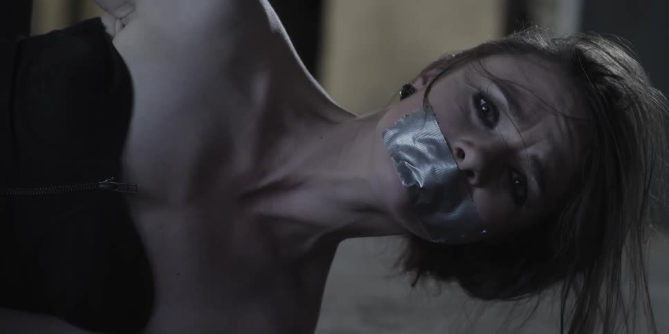 A woman falls over with tape over her mouth