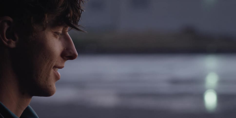Close up of the profile of a handsome young man talking outdoors
