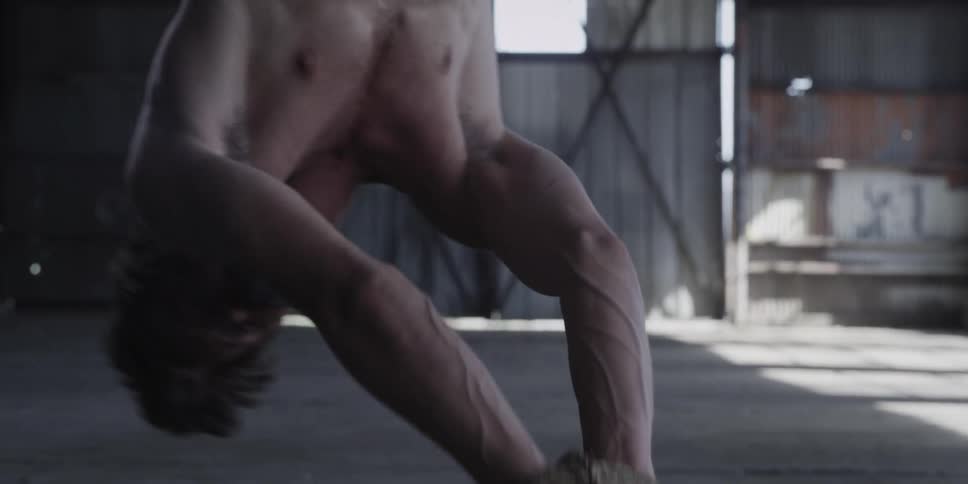 A man swings back and forth while trying to free himself from hanging upside down and tied up