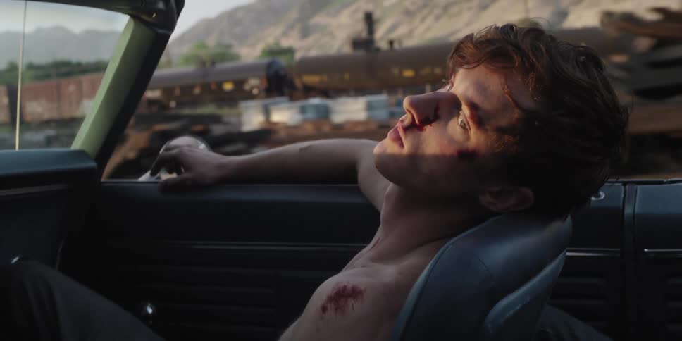 An injured man rides in the passenger seat of the car