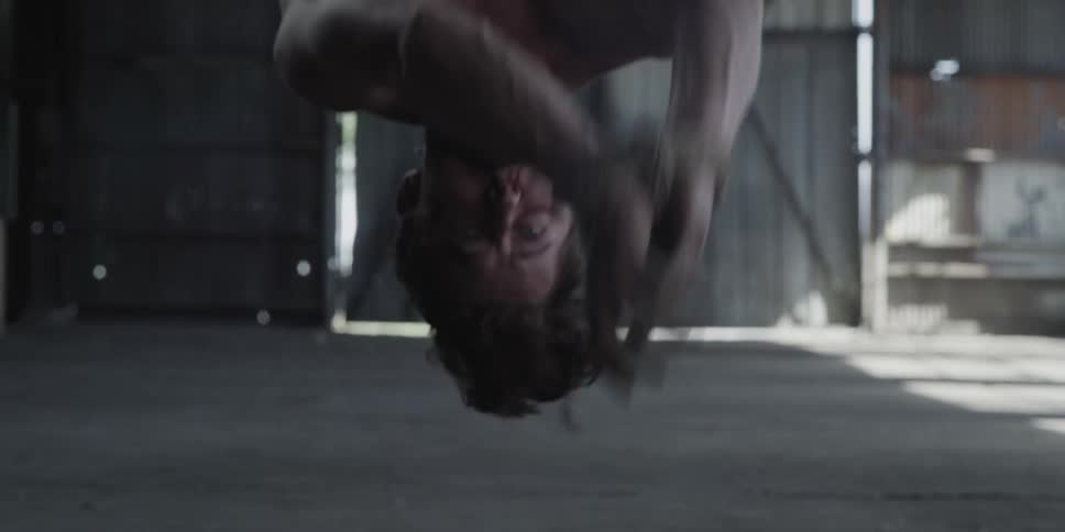 A man is tied up and gagged as he hangs upside down trying to free himself