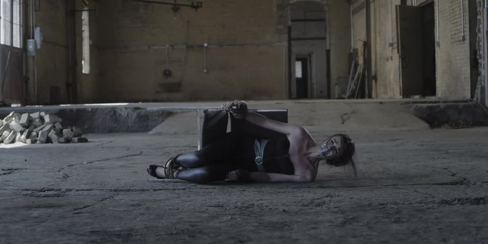 A woman tries to scream through her duct taped mouth as shes tied to a chair tipped on its side