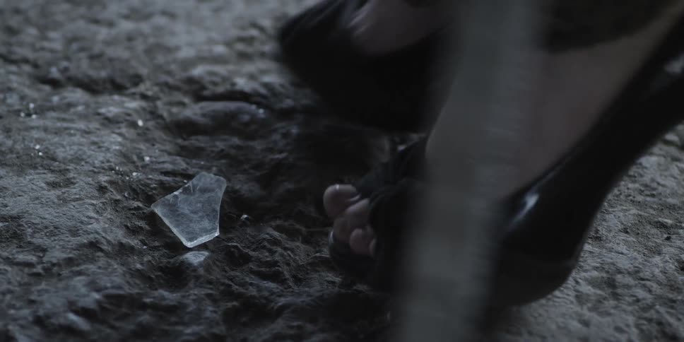 A person kicks a piece of glass