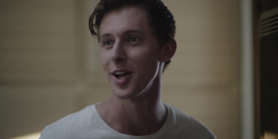 Clean shaven man with white shirt smiles and talks to person