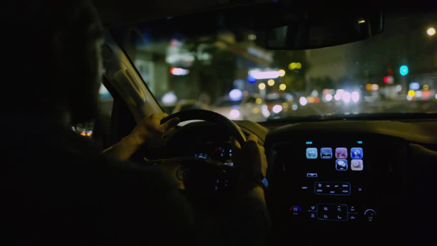 A man in a vehicle turning a steering wheel