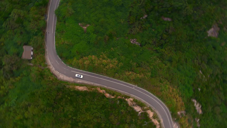 A car traveling on a highway through a wooded area