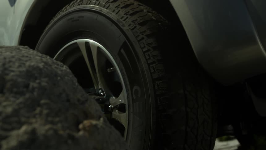 A car slowly moves around rocks