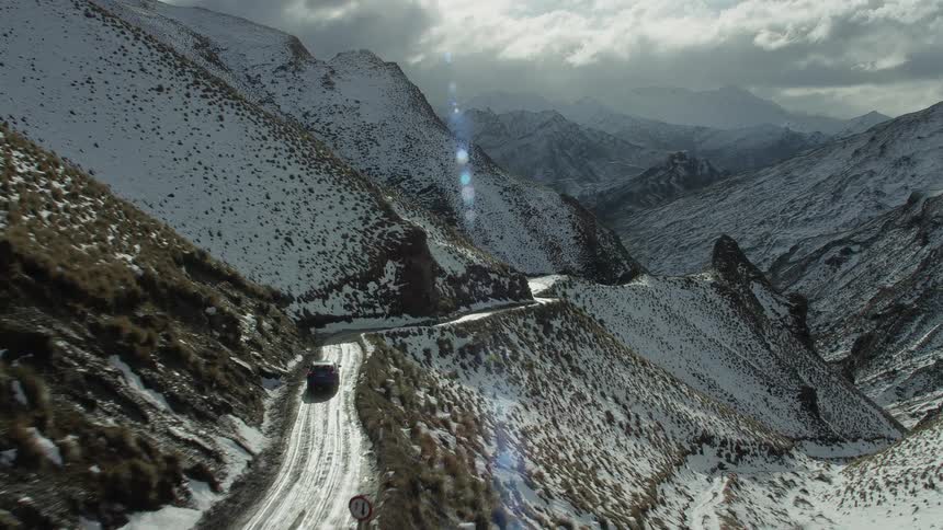 A car drives on the small mountain road