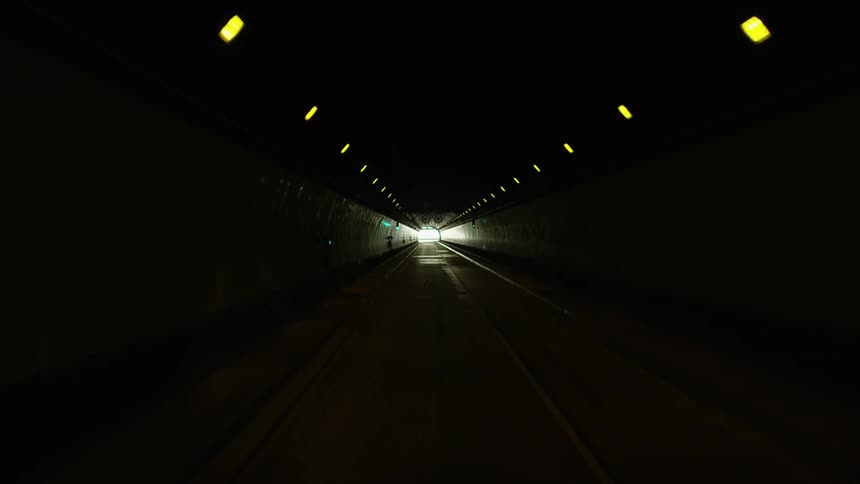 Vehicle drives through dark tunnel