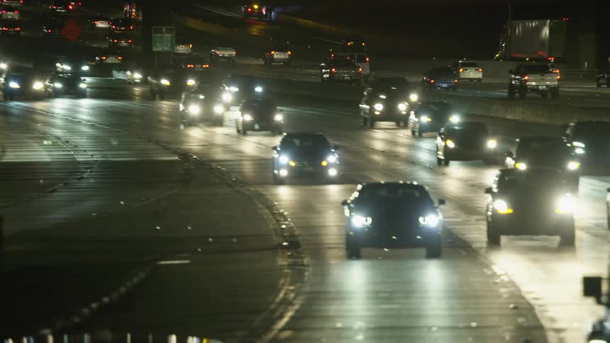 Traffic travels along a busy freeway at night