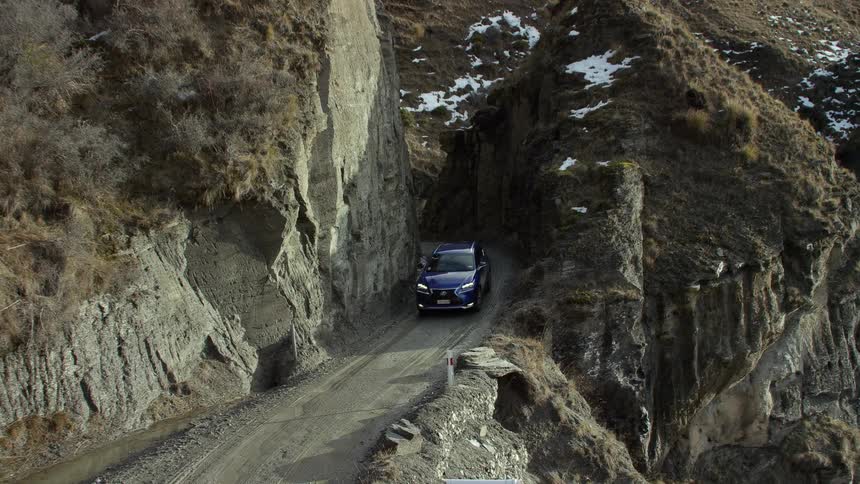 A vehicle driving on a road near a cliff
