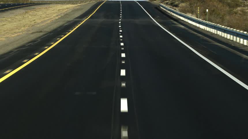 A road with freshly painted lines in a flat grassy area