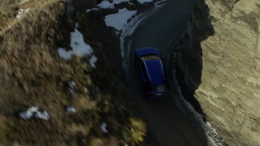 The vehicle is driving on the winding mountain road
