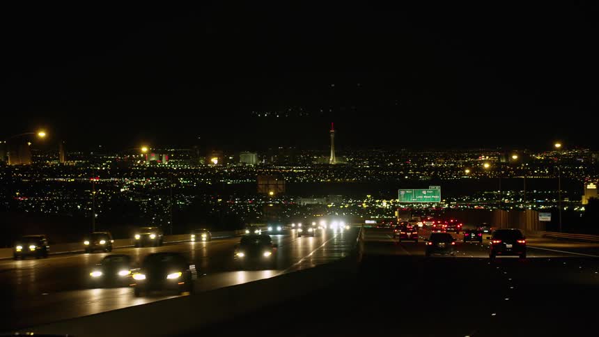 A highway with vehicles and signs with buildings and the sky and the background