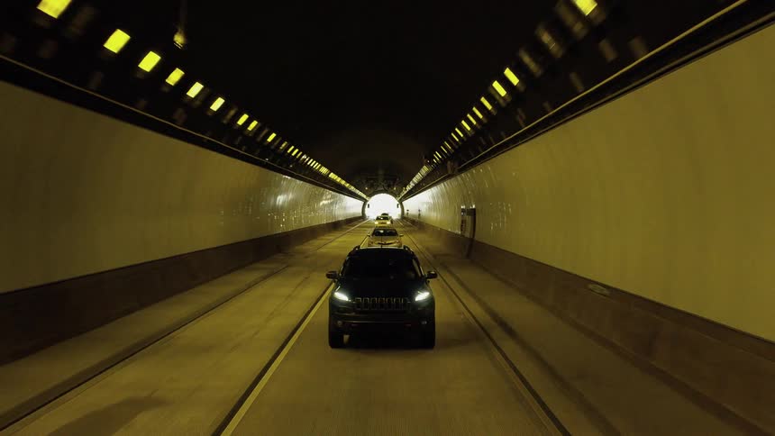 A group of vehicles travel through a tunnel