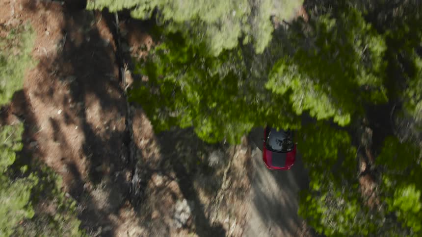 A car is driving on the dirt road