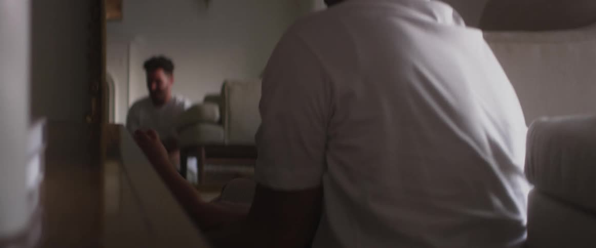 Father holds smiling child upside down over his head before kissing and setting the child down