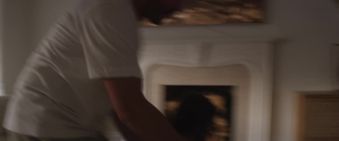 A father playfully carries his child around the living room
