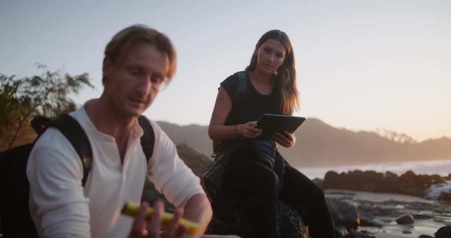 A man and woman are having a discussion as the man looks at an instrument