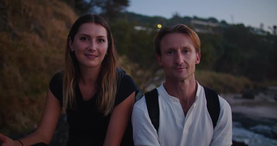 A man and woman sitting outside smiling