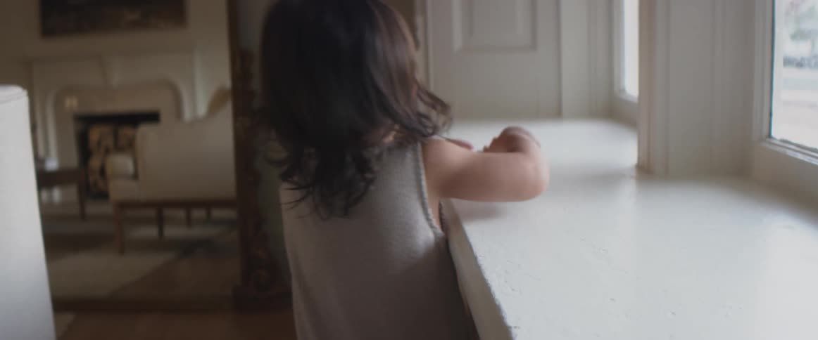 A small child playing with a toy truck in a room on a counter