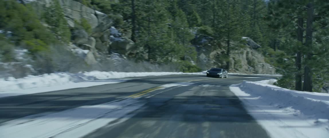 A car moves fast down a twisting road