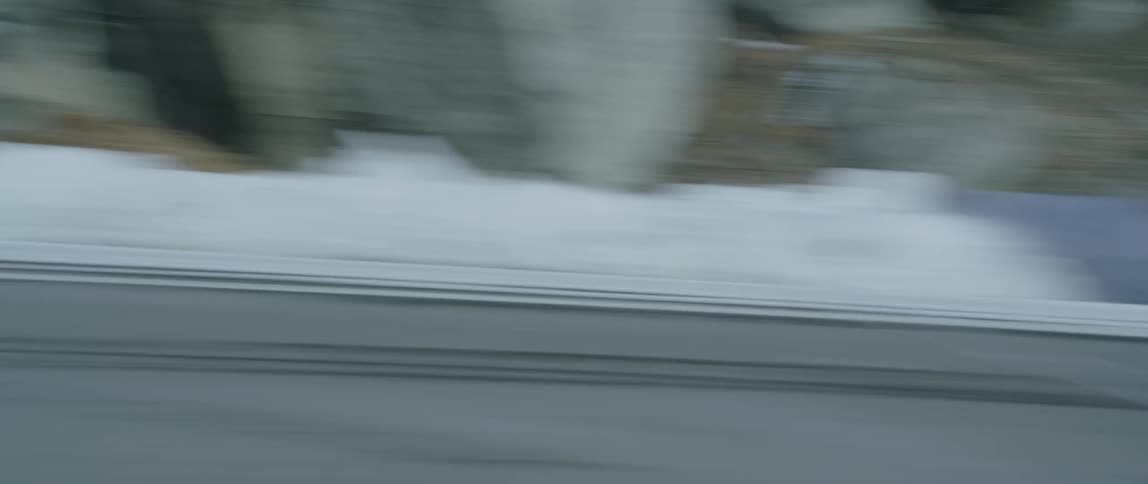 Snowbanks and lines in the road are sped past